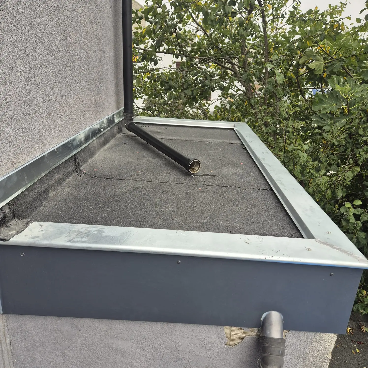 Évacuation d'eaux pluviales et zinguerie refaites sur une toiture plate